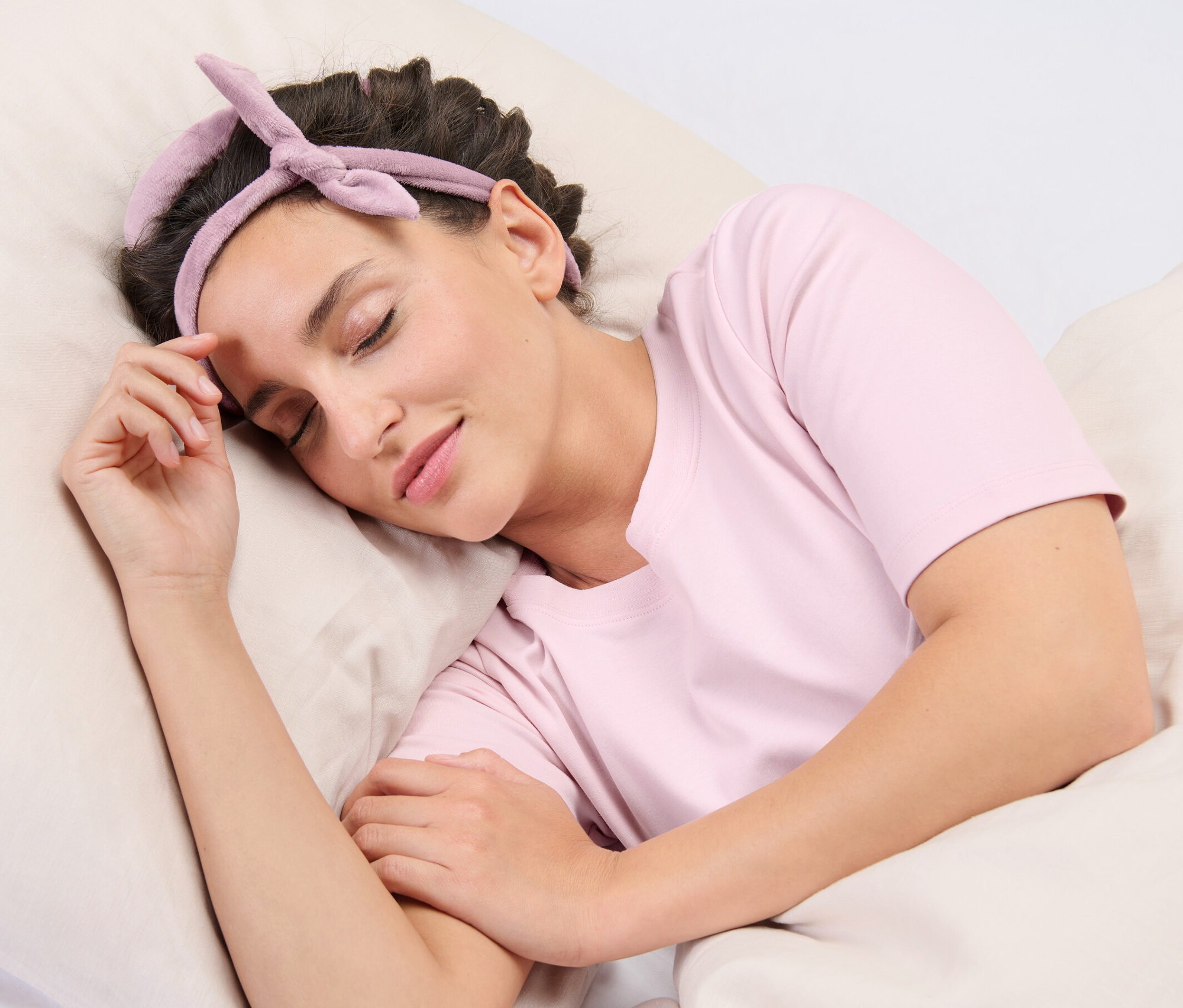 Bir kadın yastıkta uyuyor ve saçında Isısız Bigudi var.