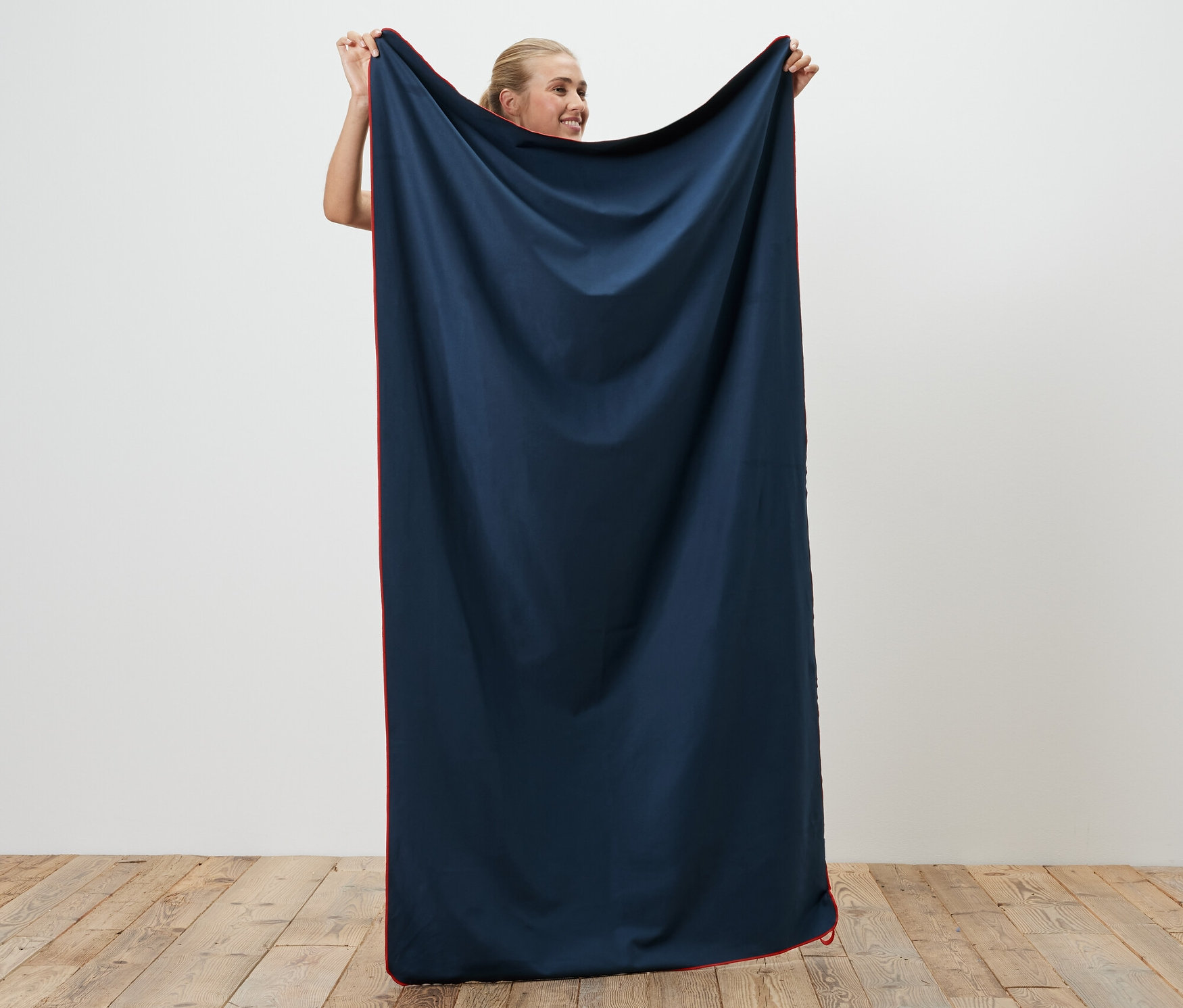 Kadın, yakl. 100 x 180 cm boyutlarında bir Outdoor Banyo Havlusu tutuyor.