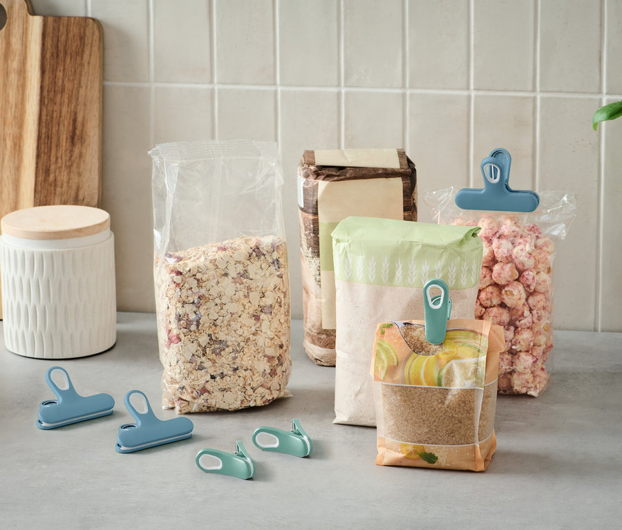 Bir mutfak tezgahında renkli klipslerle kapatılmış birkaç açık yiyecek torbası duruyor.