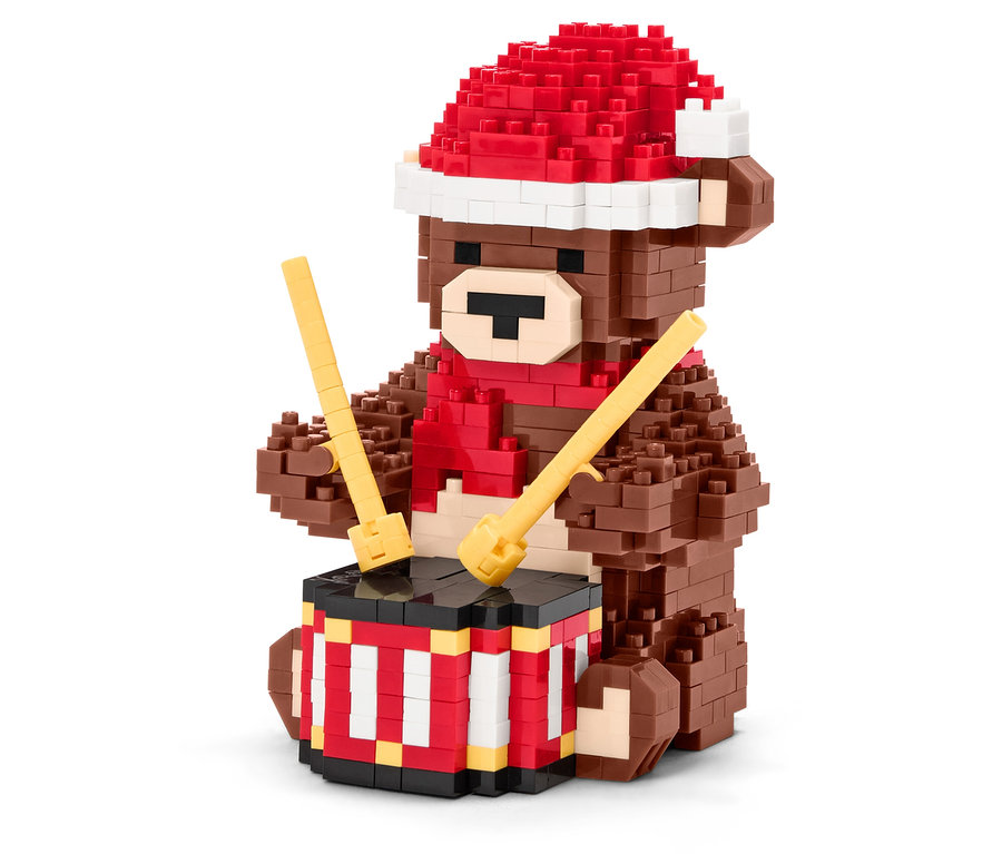 Kırmızı şapkalı ve atkılı kahverengi yapboz ayı, bagetlerle davul çalıyor.