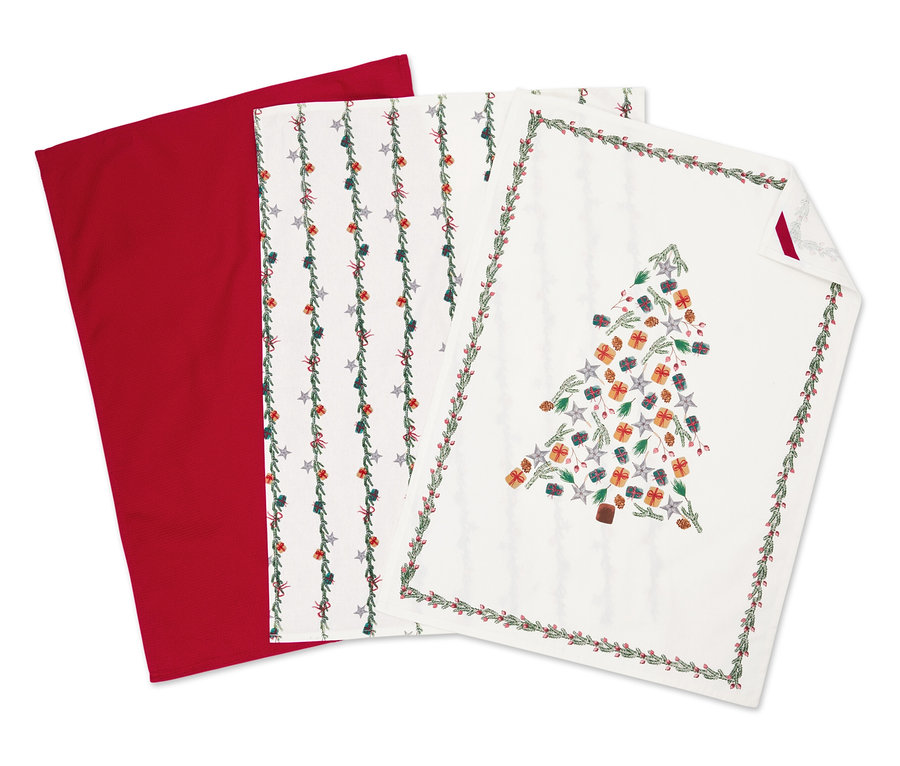 Üç adet kumaş peçete: bir kırmızı, bir yıldız desenli ve bir Noel ağacı desenli.
