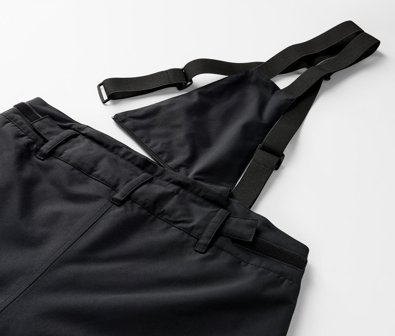 Siyah salopet pantolonun ve lastikli askılarının yakın çekim detayı.