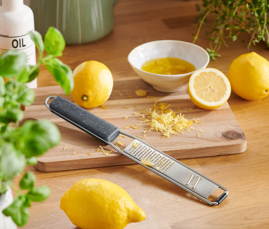 2'si 1 Arada El Rendesi limonlar ve rendelenmiş kabuklarla birlikte ahşap bir tahta üzerinde duruyor.