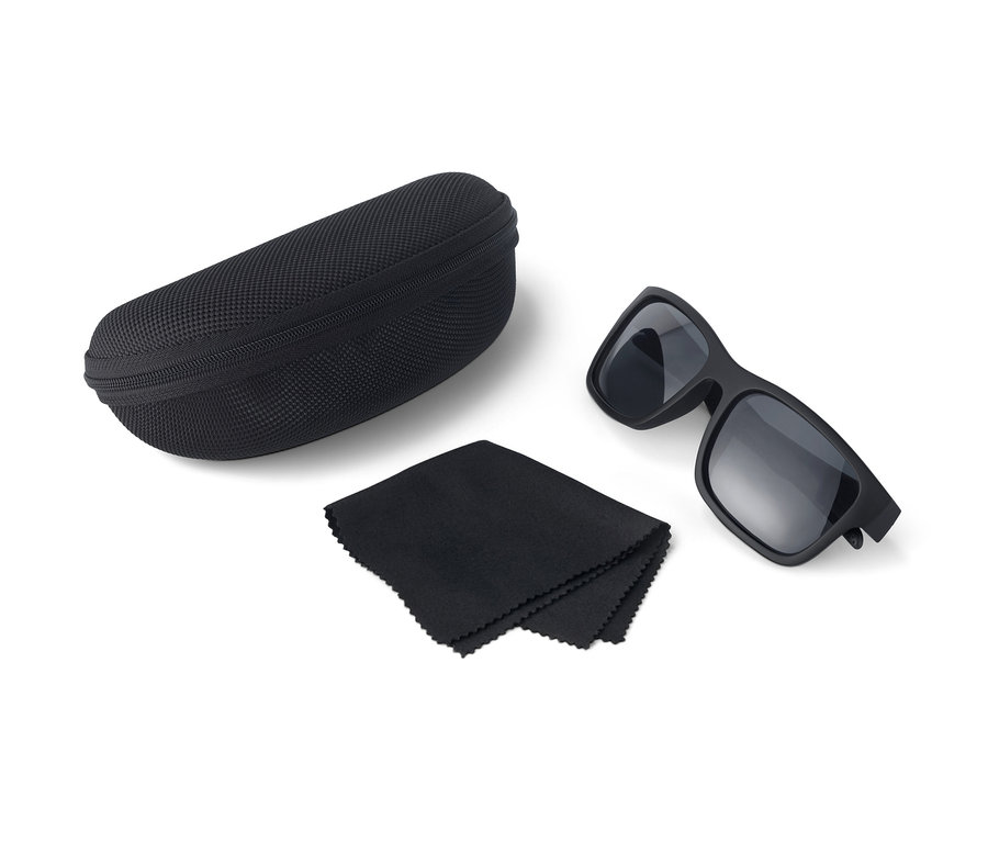Beyaz bir arka planda siyah yüzen güneş gözlüğü, kutu ve bez.