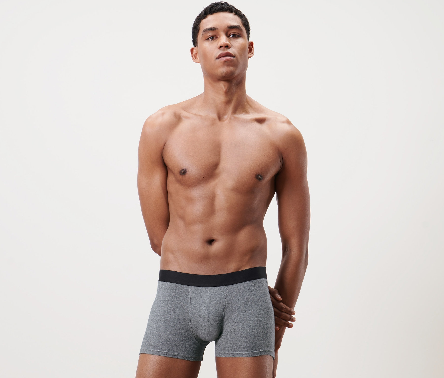 Gri 2 Adet Slip Boxer külot giyen bir adam poz veriyor