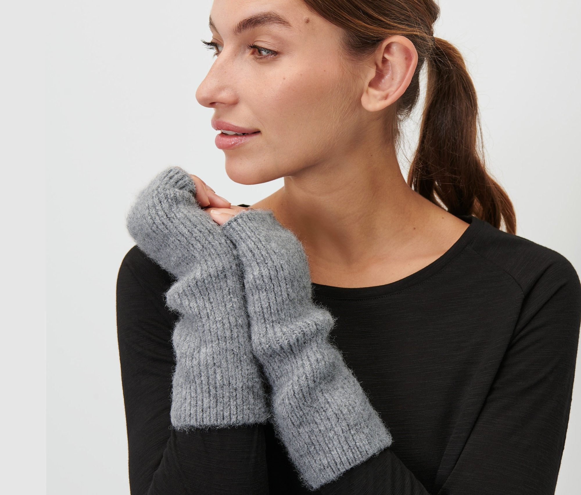 Kadın gri parmaksız eldivenler takıyor.