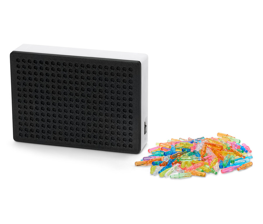 Beyaz çerçeveli siyah ışıklı tablet, bir yığın renkli mandalın yanında.