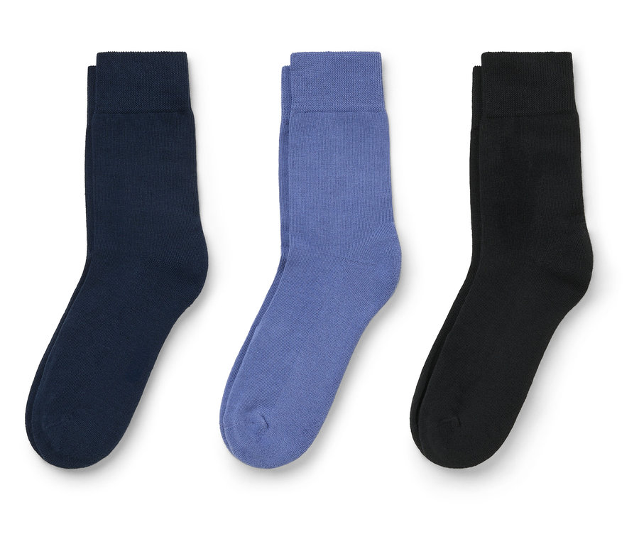 Lacivert, mor ve siyah renklerde üç çorap beyaz bir arka plan üzerinde duruyor.