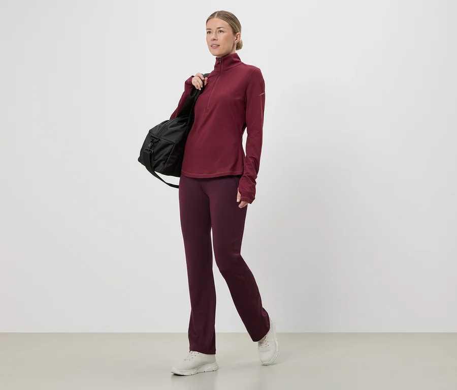 Bordo renkli spor üst ve pantolon giyen, omzunda siyah çantası olan kadın, beyaz spor ayakkabılar.