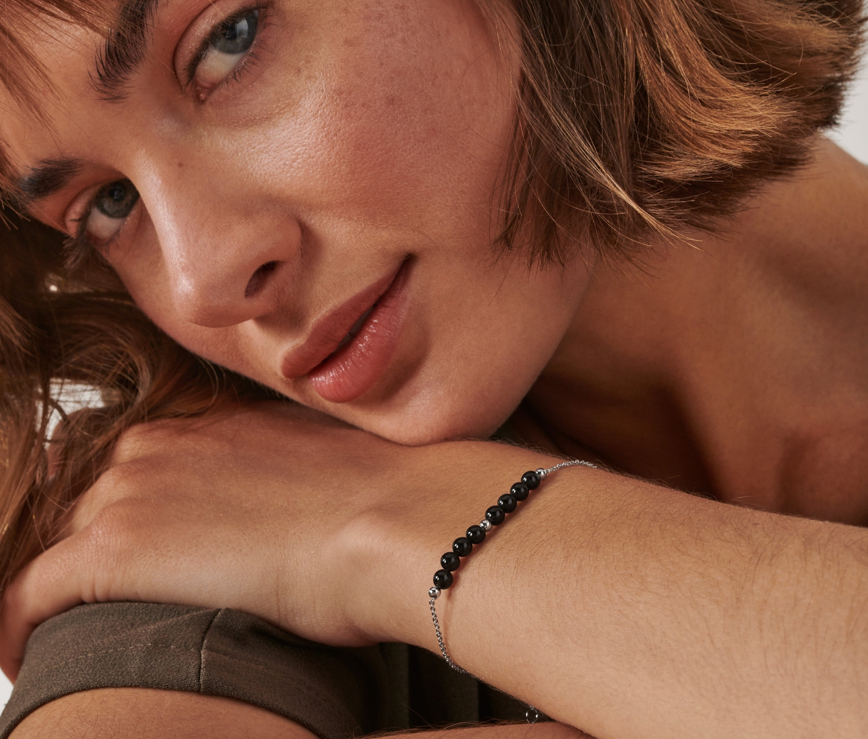 Bileğinde obsidyen bileklik olan kadın