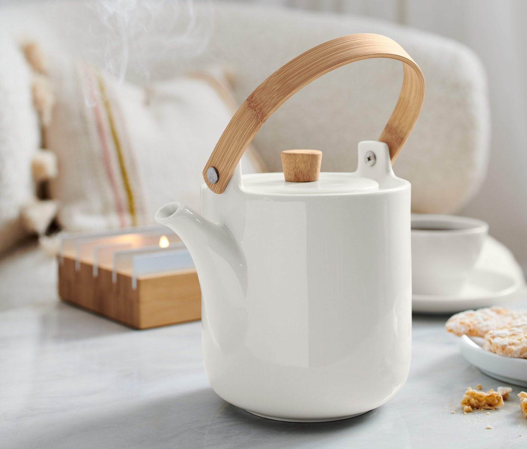 Bir çaydanlık masanın üzerinde duruyor. Çaydanlıktan duman çıkıyor.