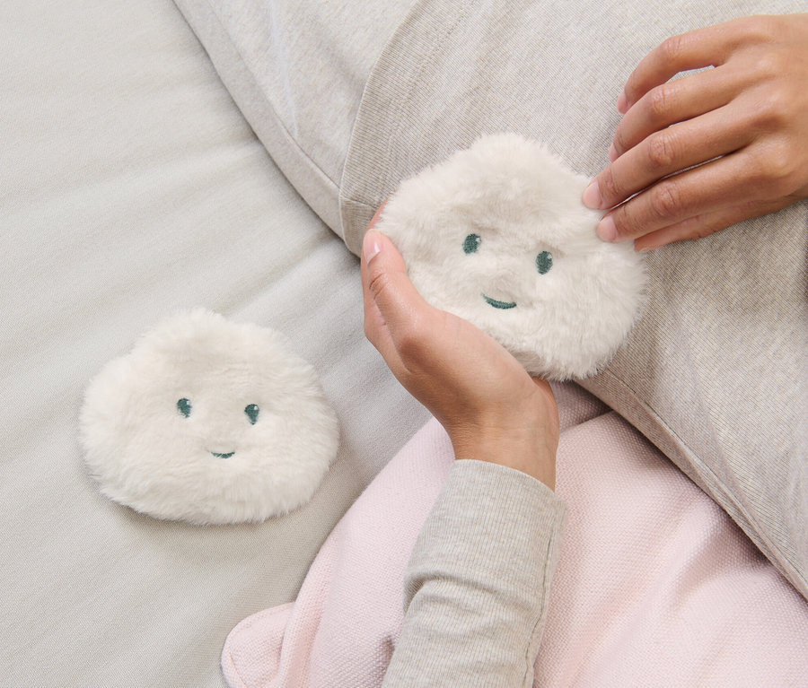 Kadın elinde 2 Adet Cep Isıtıcı Pedden birini tutuyor.