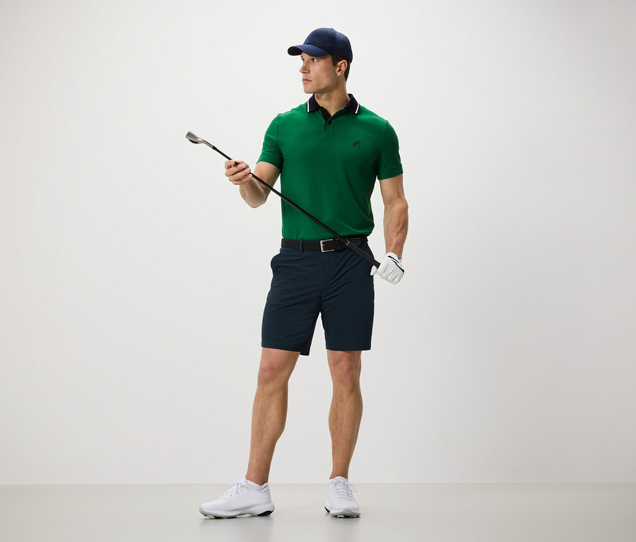 Adam golf sopası tutuyor ve fonksiyonel şort giyiyor..