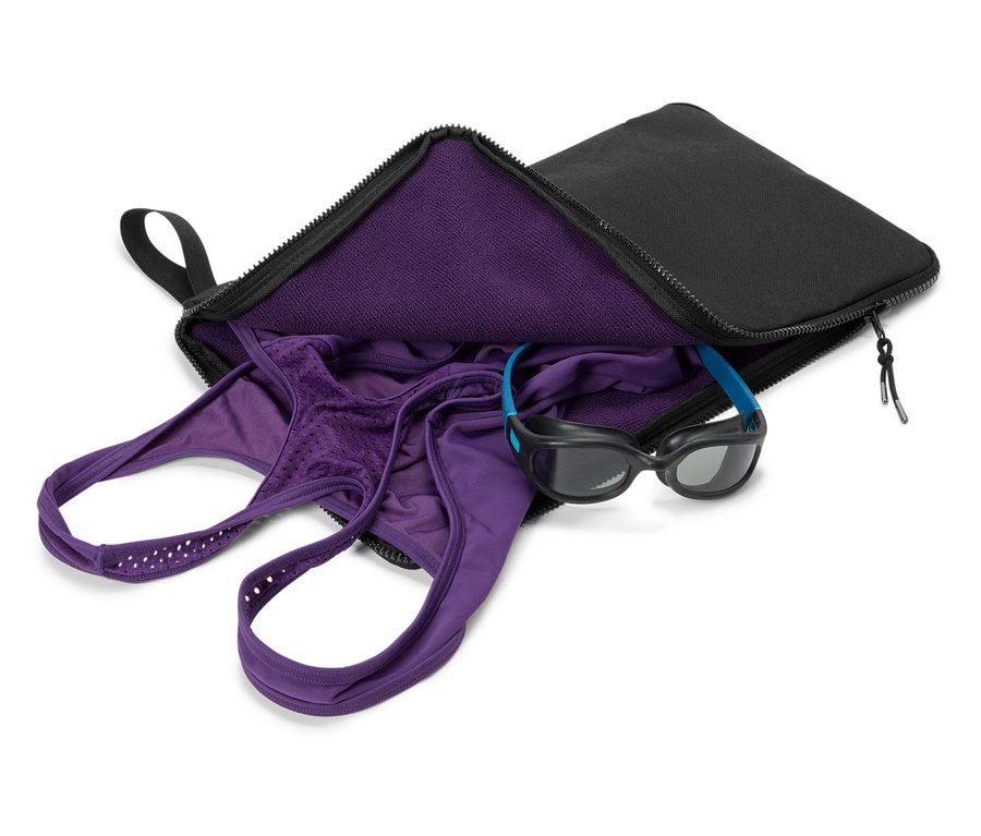 Siyah bir çantada mor mayo ve yüzme gözlüğü.