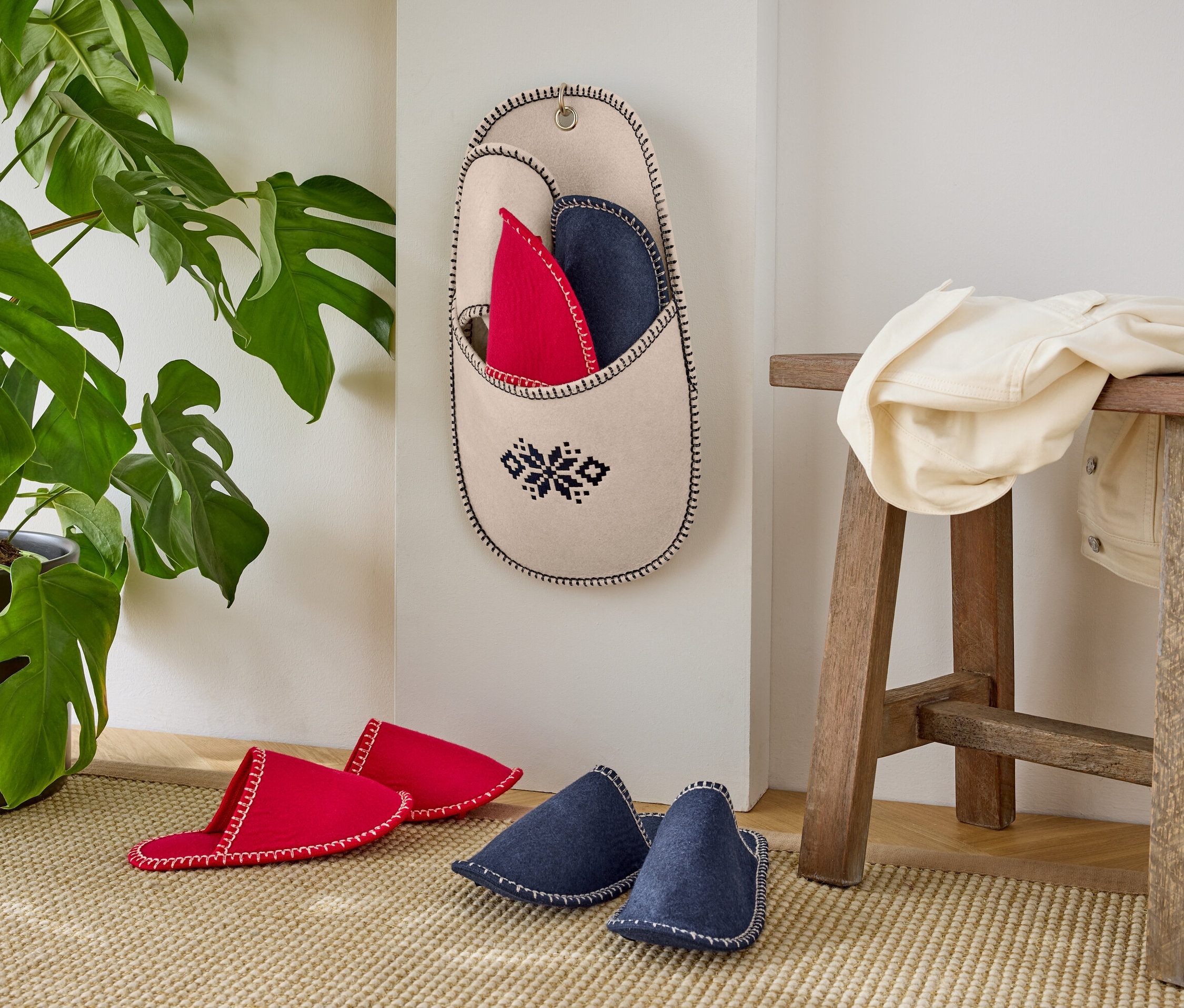 Saksı bitkisi olan duvarda kırmızı ve mavi terlikler.