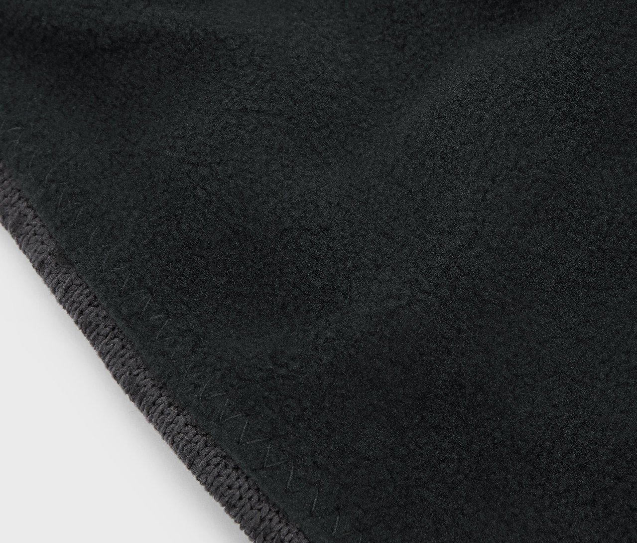 Gri bordürlü siyah bir kumaşın yakın çekimi.