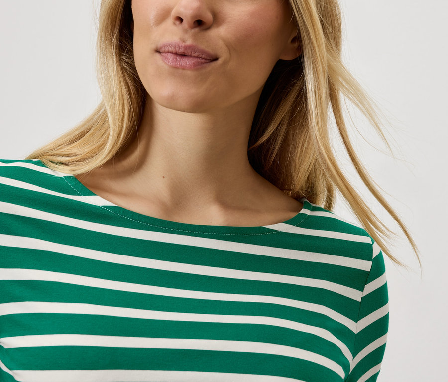 Sarışın bir kadın çizgili bir tişört giyiyor.
