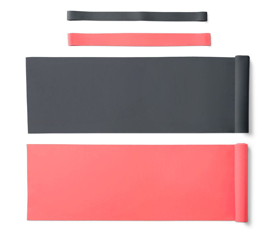 Beyaz bir arka plan üzerinde iki gri ve iki mercan renkli fitness bandı ve lastik bant.