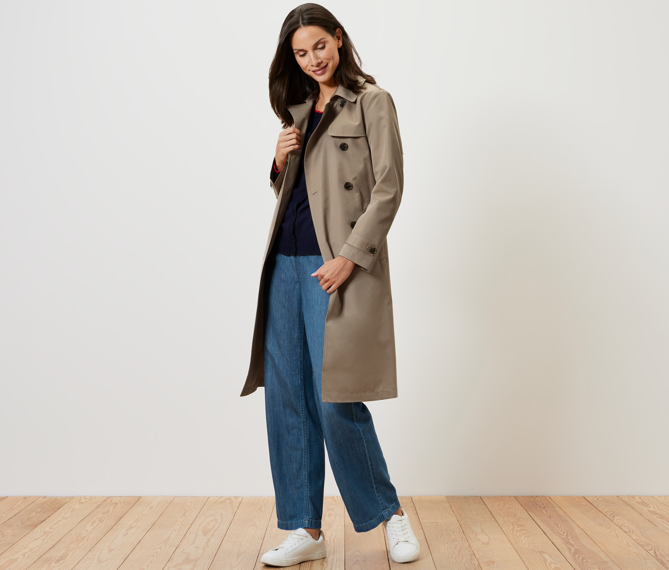 Kadın bej rengi bir trençkot giyiyor