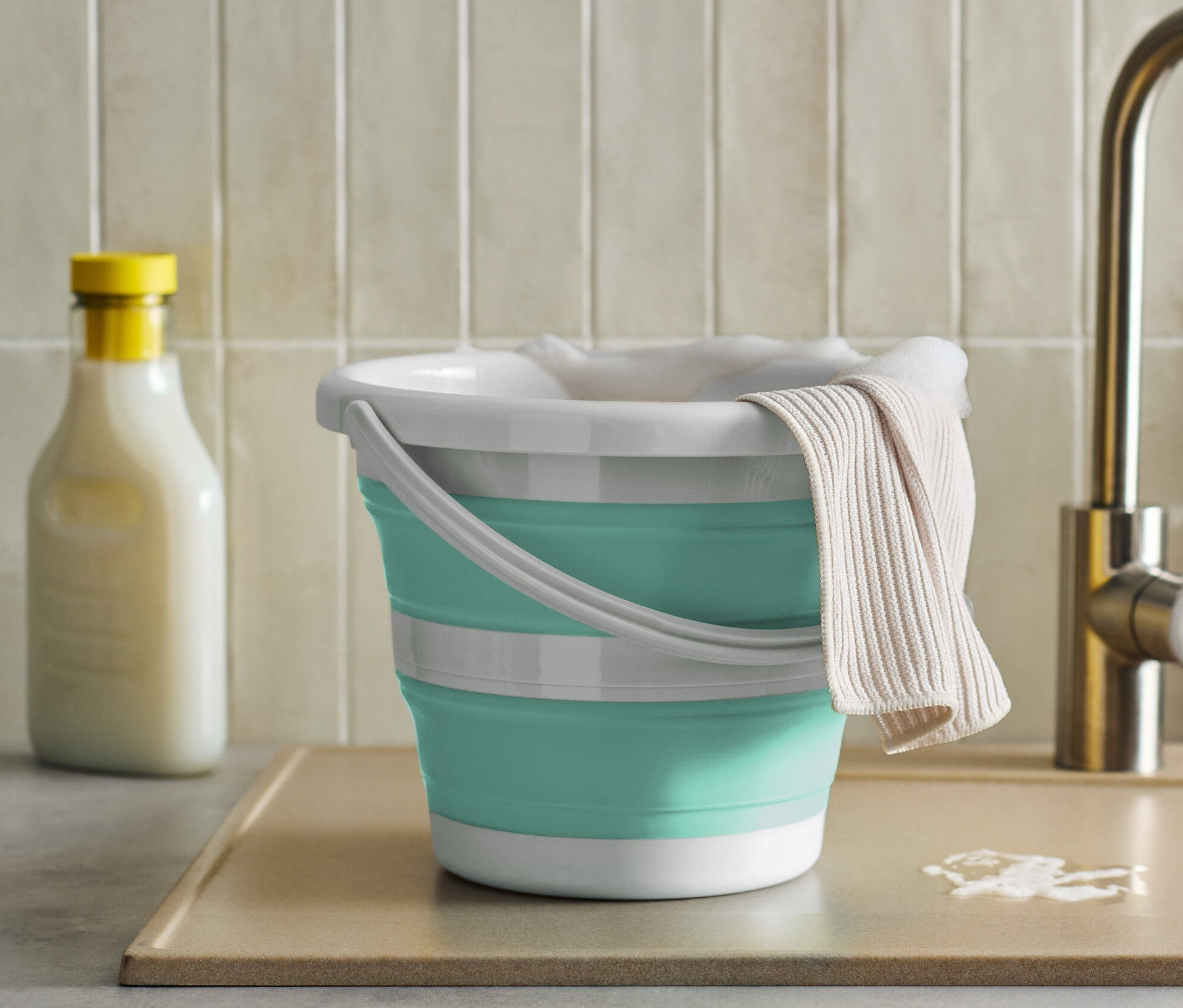 Mutfak lavabosunun yanında bezi olan katlanabilir kova.