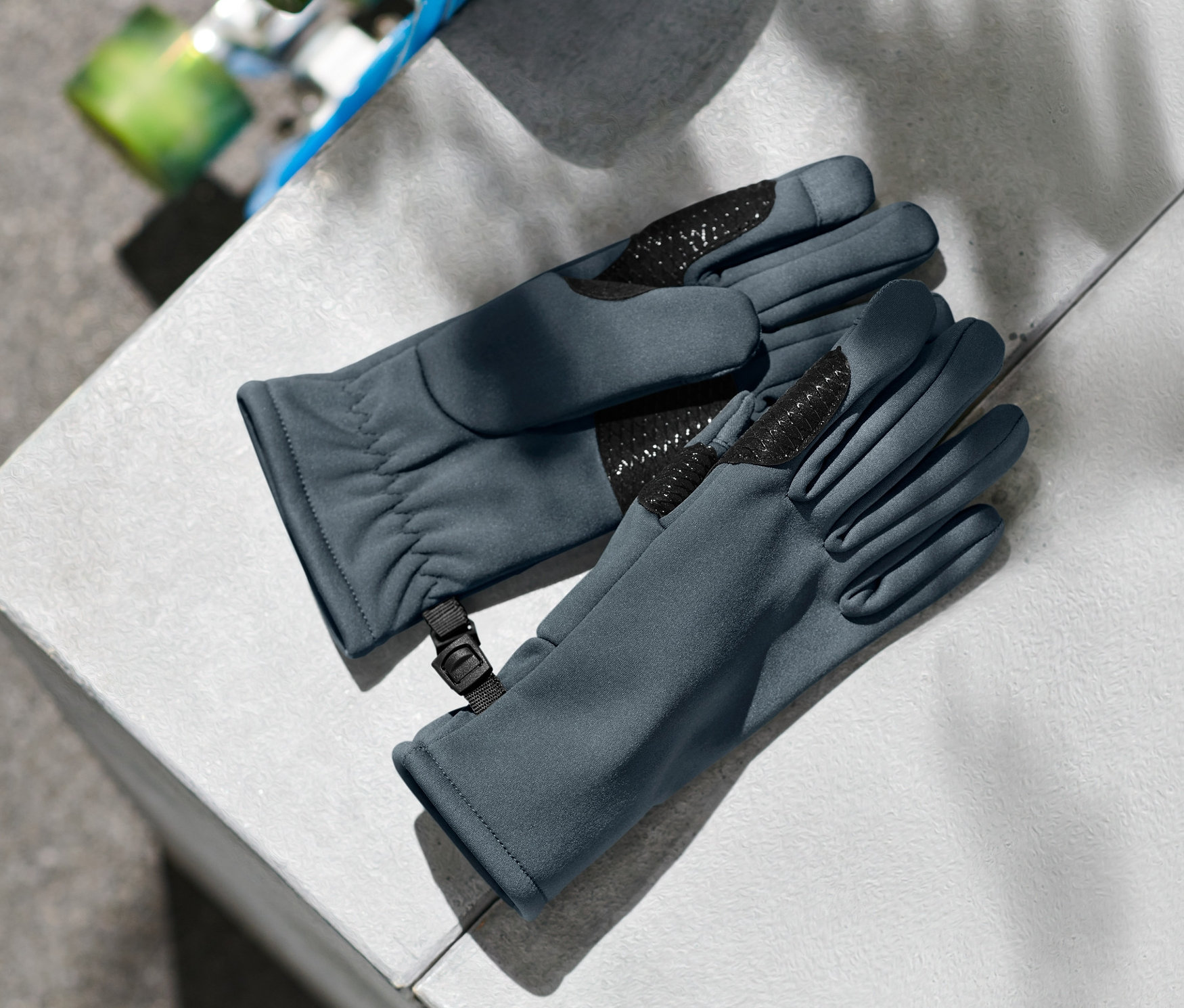 İki adet çocuk softshell eldiven gri bir küpün kenarında duruyor.
