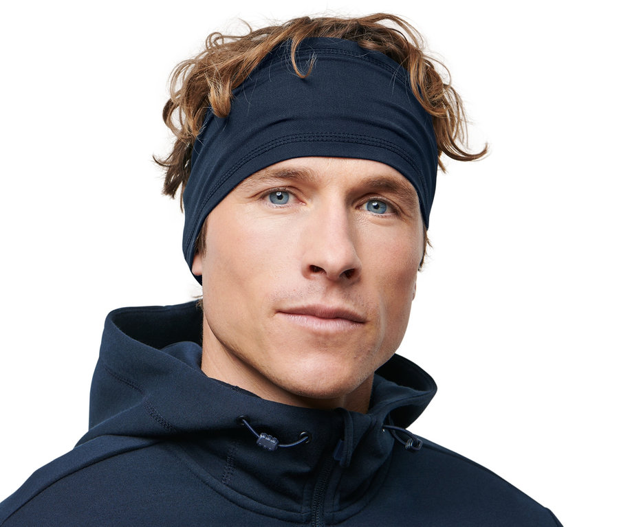 Kahverengi saçlı ve mavi gözlü bir adam Spor Saç Bandı takıyor.