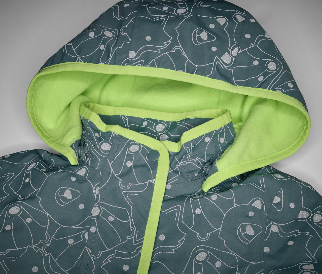 Yansıtıcı detayları, kapüşonu ve hayvan desenli çocuk termo yağmurluğunun yakın çekimi.