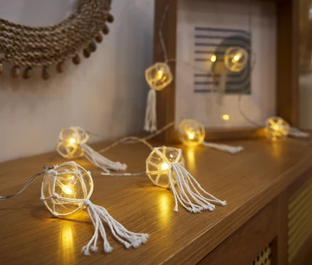 LED-Kugel-Lichterkette ahşap bir komodinin üzerinde duruyor.