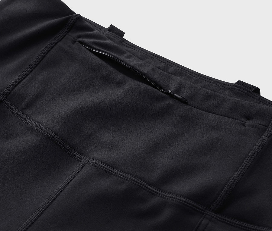 Fermuarlı cepli siyah bir outdoor taytının yakın çekim görüntüsü.