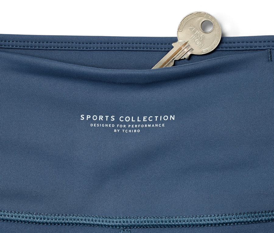 Cebindeki gümüş anahtarla birlikte mavi renkli 7/8 spor taytının detayı.