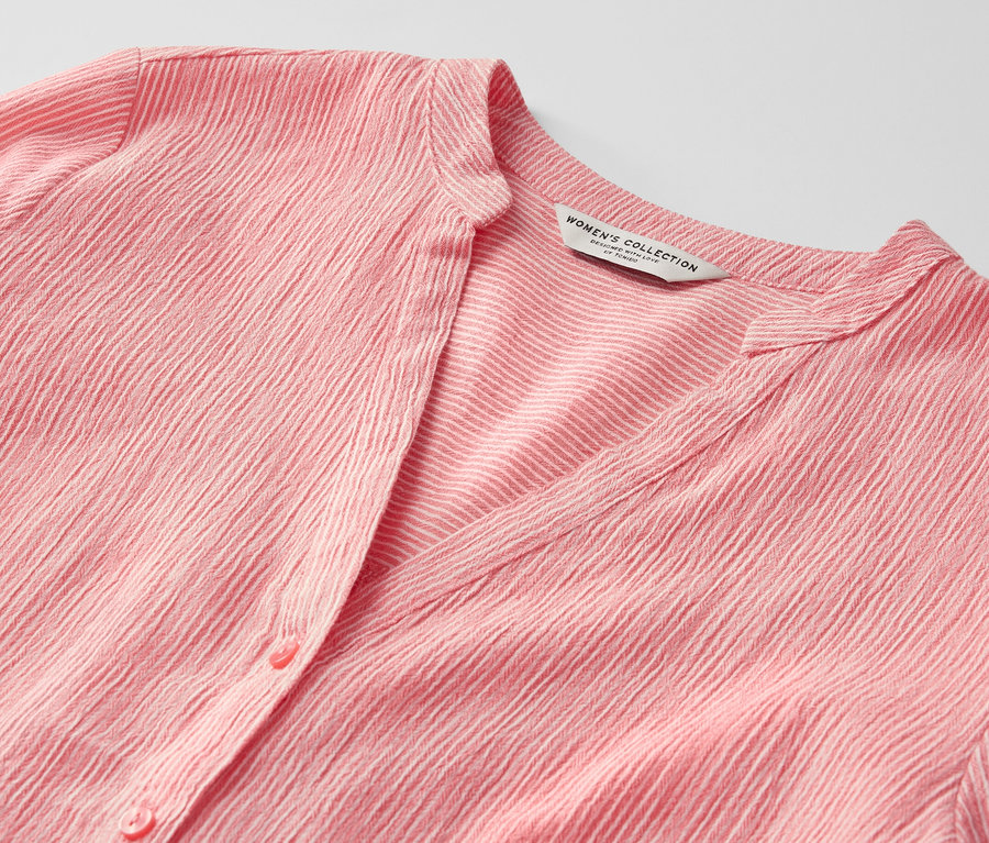 Çizgili, mercan rengi uzun tuniğin yakın çekimi.