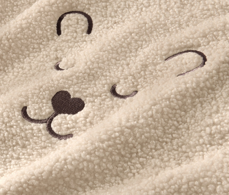 Pelüş kazağın üzerinde ayı yüzü işlemesi detayı. 