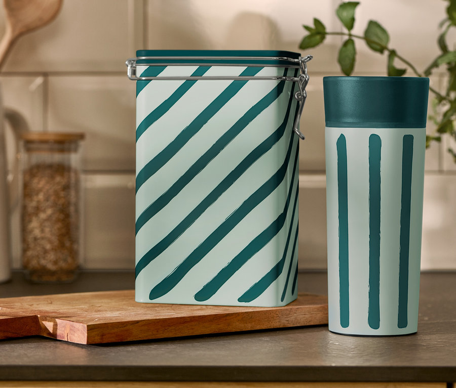 Çizgili kahve kutusu ve Coffee-to-go Kupası bir mutfak masasının üzerinde duruyor.
