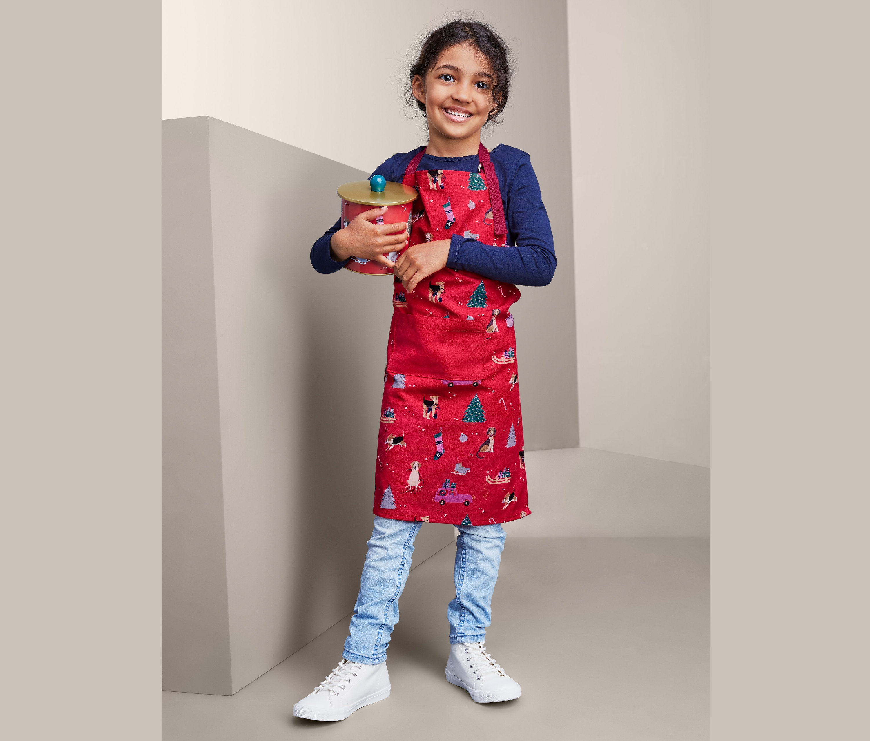 Mutfak önlüklü kız çocuğu kutu tutuyor.