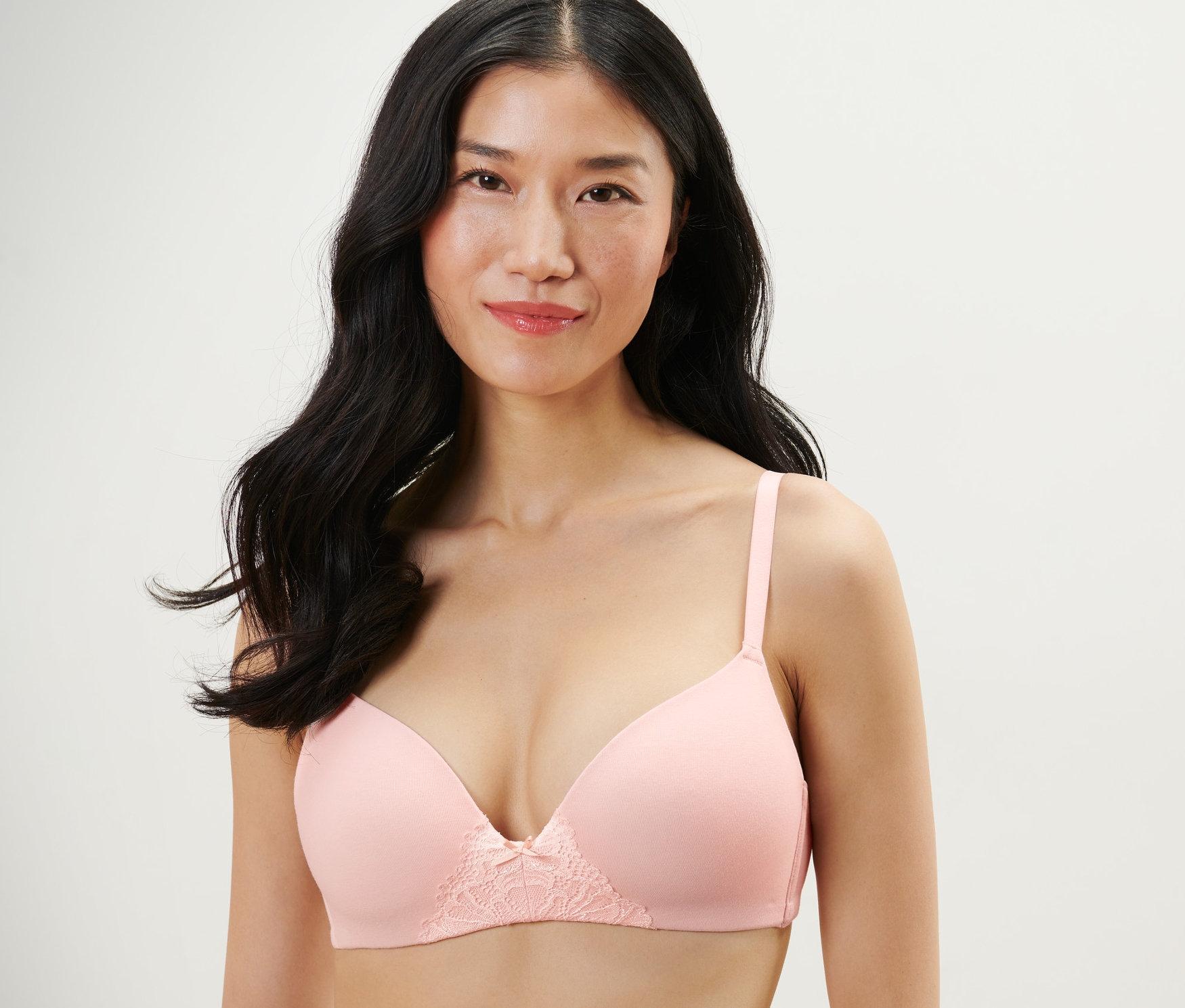 Kadın pembe yumuşak kuplu sütyen giyiyor.