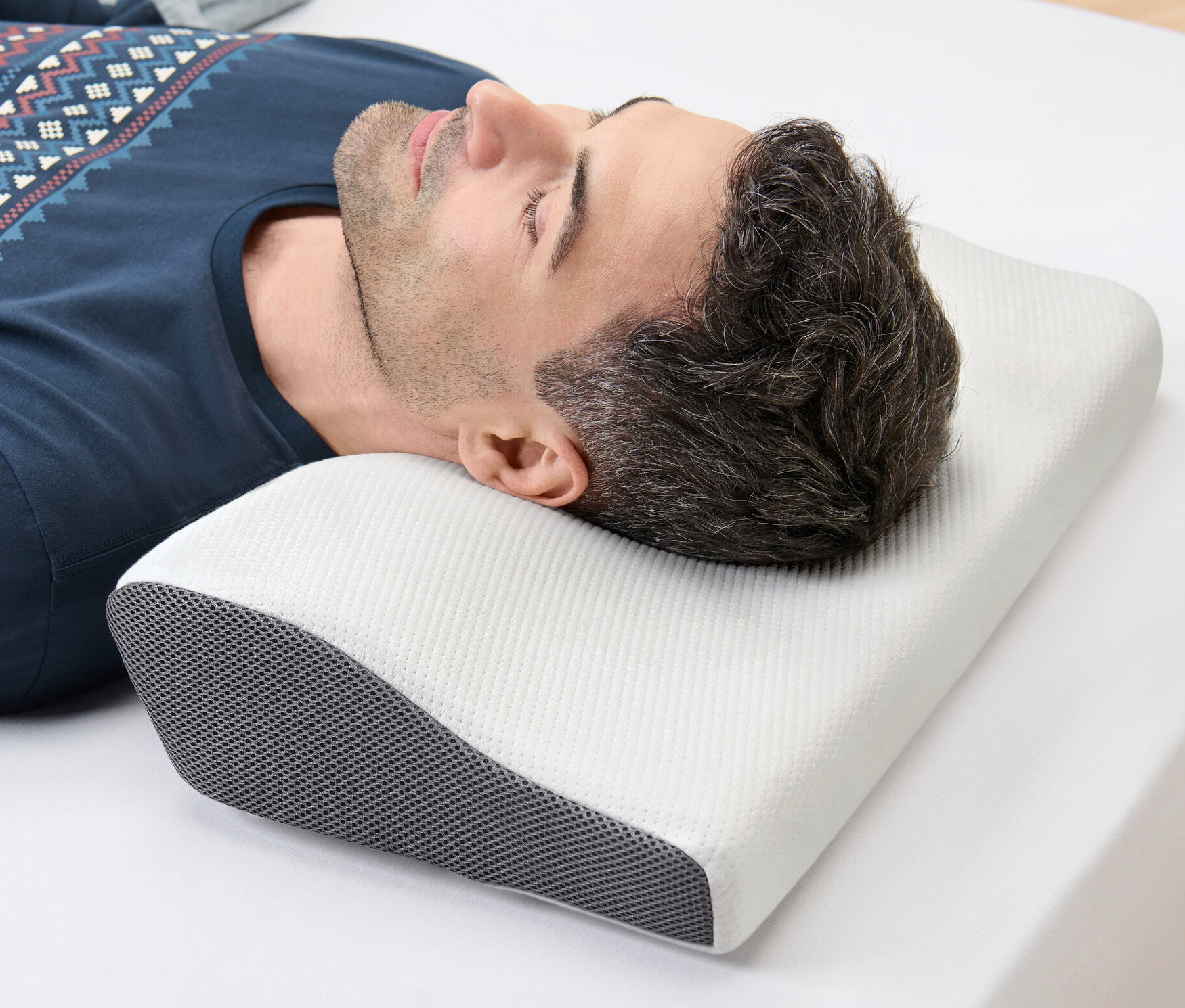 Adam beyaz bir çarşafın üzerinde yan yatar ve başı Boyun Destek Yastığı üzerinde durur.