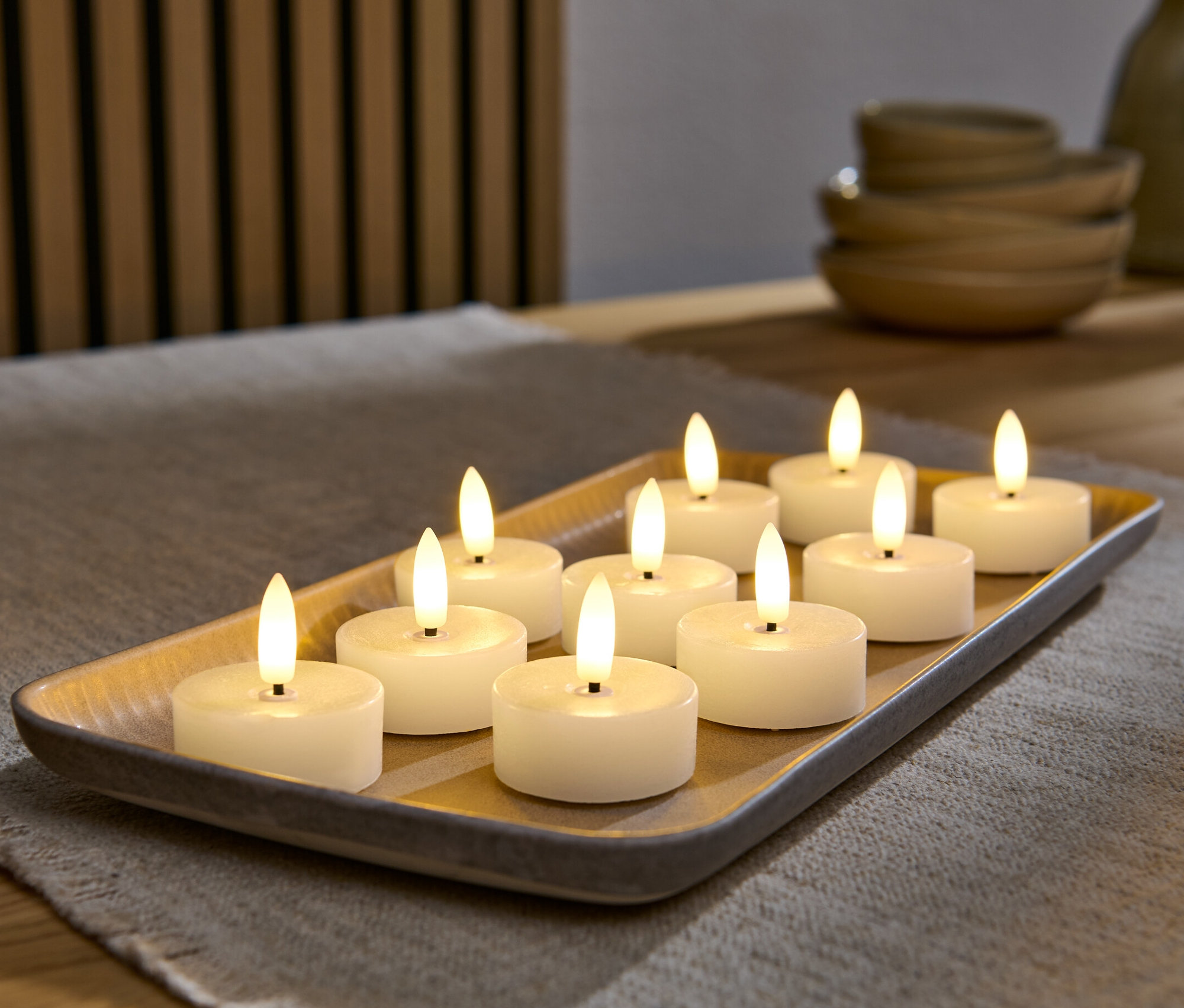 Bir tepside on adet krem rengi LED gerçek mum tealight bulunuyor.