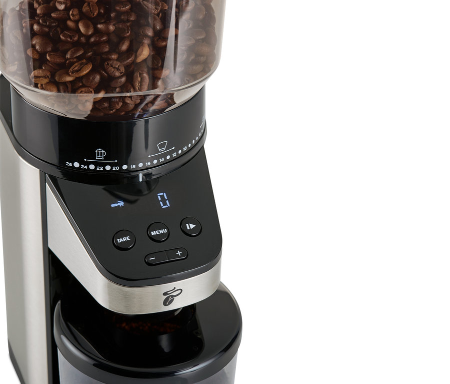 Üzerinde kahve çekirdekleri bulunan, tartılı, elektrikli kahve değirmeninin yakın çekimi.