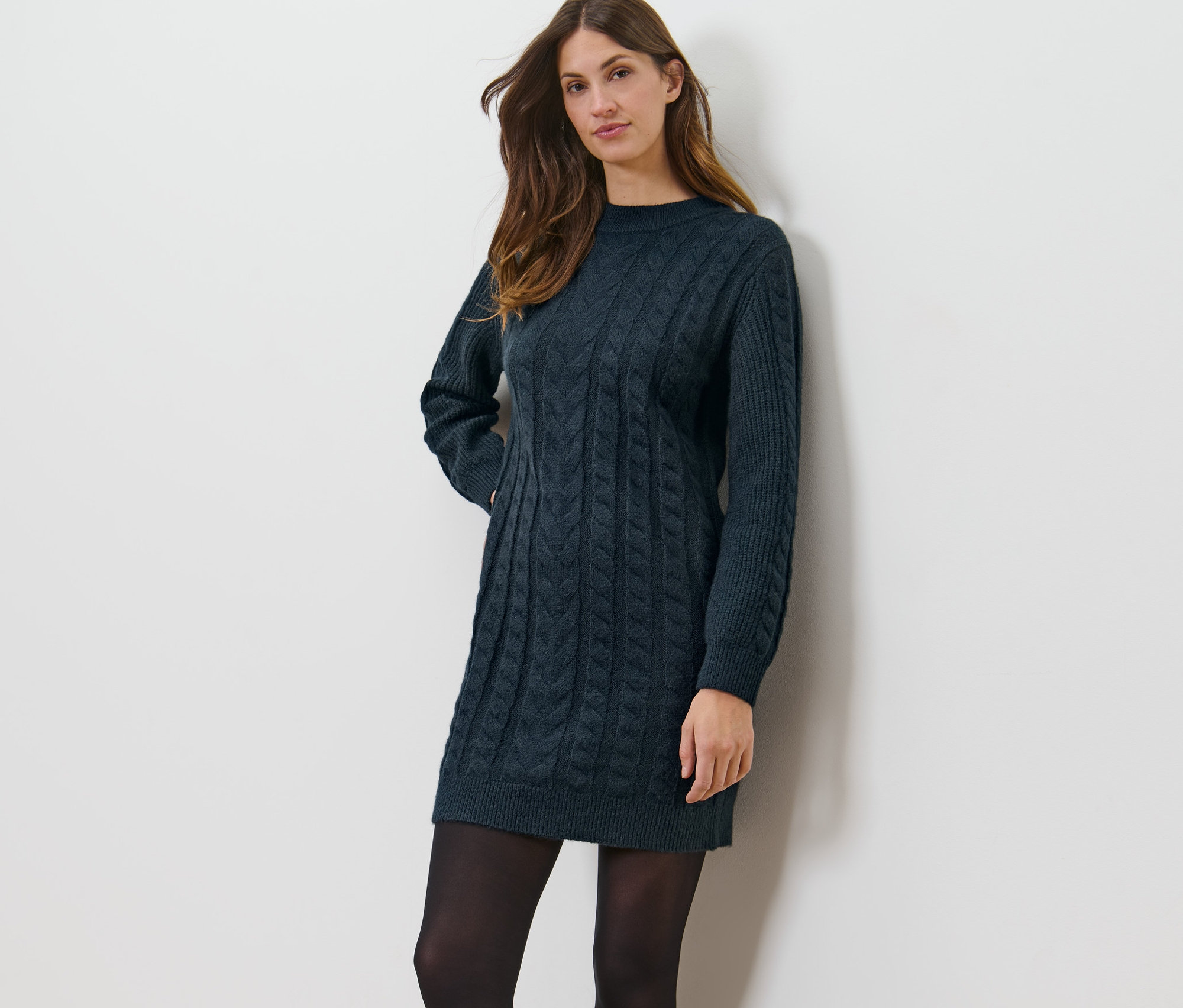 Kadın motifli örgü elbise ile poz veriyor.