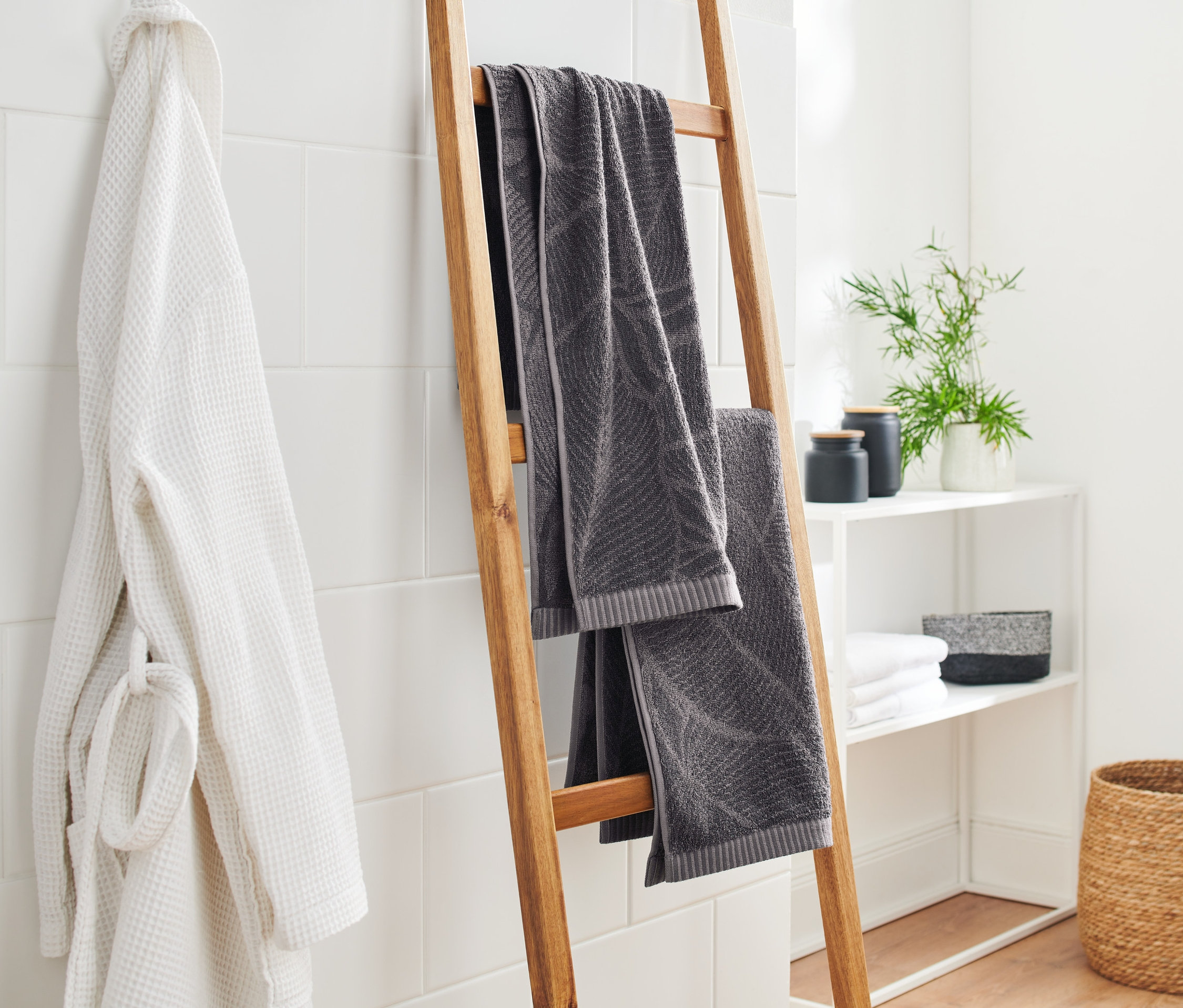 Banyoda ahşap bir merdivende asılı duran iki adet antrasit jakarlı el havlusu.