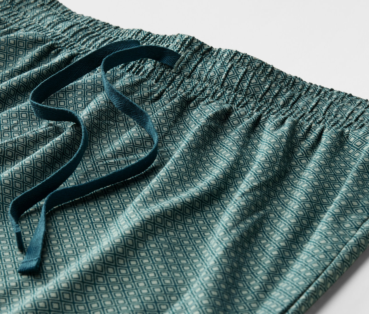 Elastik belli ve bağcıklı, yeşil desenli bir pijama altının detayı.