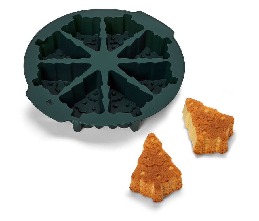 Yanında iki adet pişmiş ağaç bulunan, çam ağacı şeklinde yeşil silikon pişirme kalıbı.