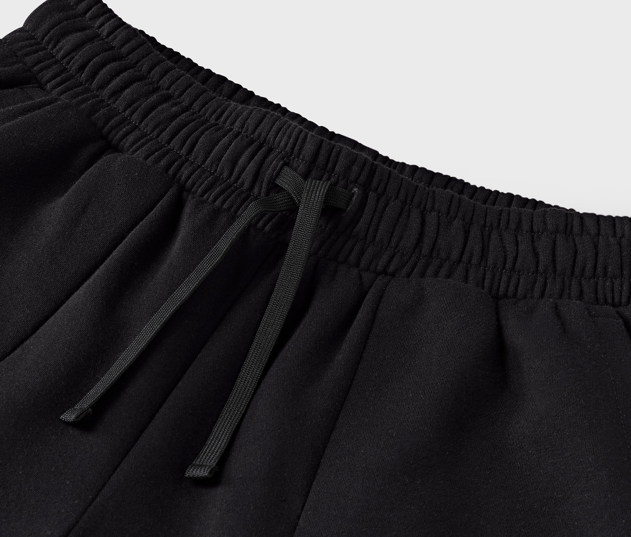 Büzgülü belli siyah eşofman altının yakın çekimi.