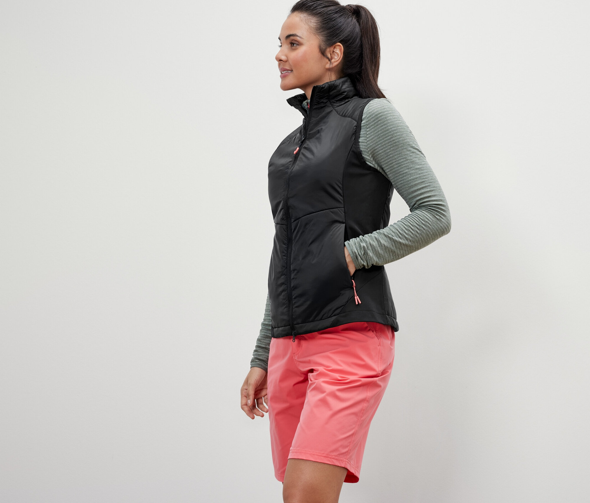 Kadın Hybrid Yelek »Pack Light«, zeytin yeşili üst ve pembe şortla poz veriyor.