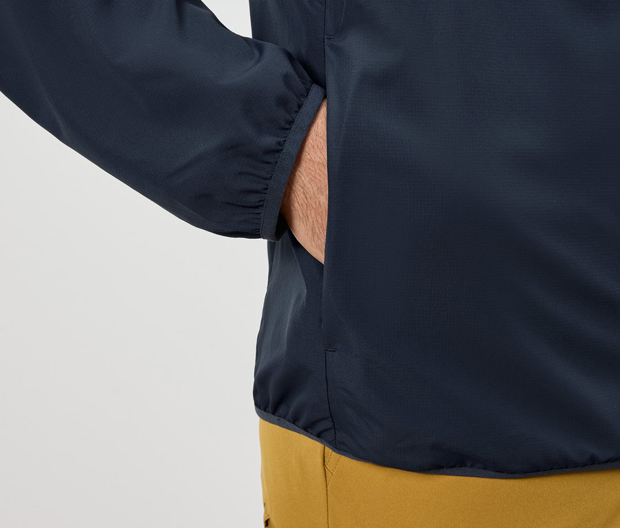 Adam elini lacivert bir ceketin cebine sokuyor.