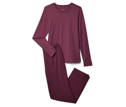 Bordo renkli, uzun kollu üst ve zikzak desenli pantolondan oluşan pijama takımı beyaz bir zeminde duruyor.