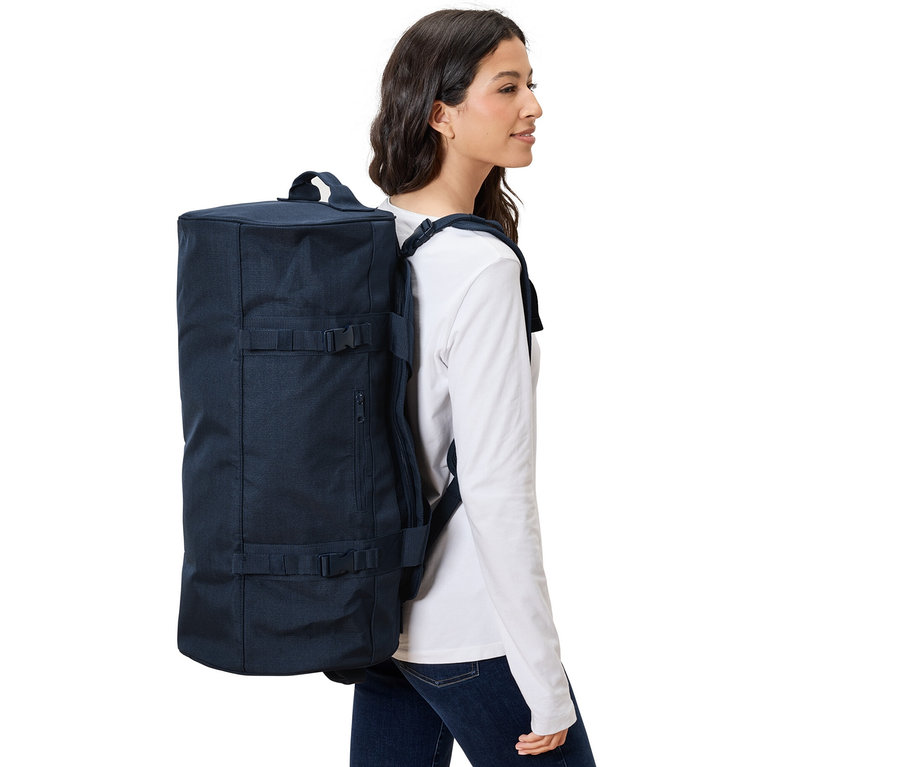 Kadın Seyahat Çantası ve Sırt Çantası taşıyor.