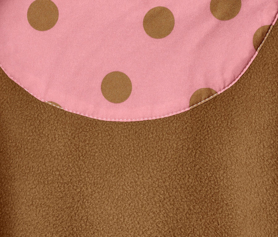 Pembe zemin üzerinde kahverengi puantiyeli ve kahverengi polar dokulu softshell tulumun detay görüntüsü.