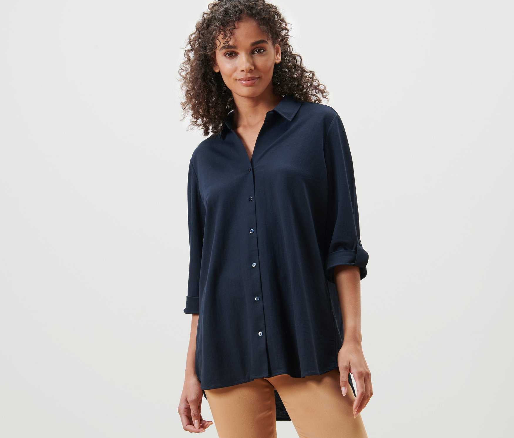 Kadın koyu mavi Pike Jersey Gömlek ve kahverengi pantolonla poz veriyor.