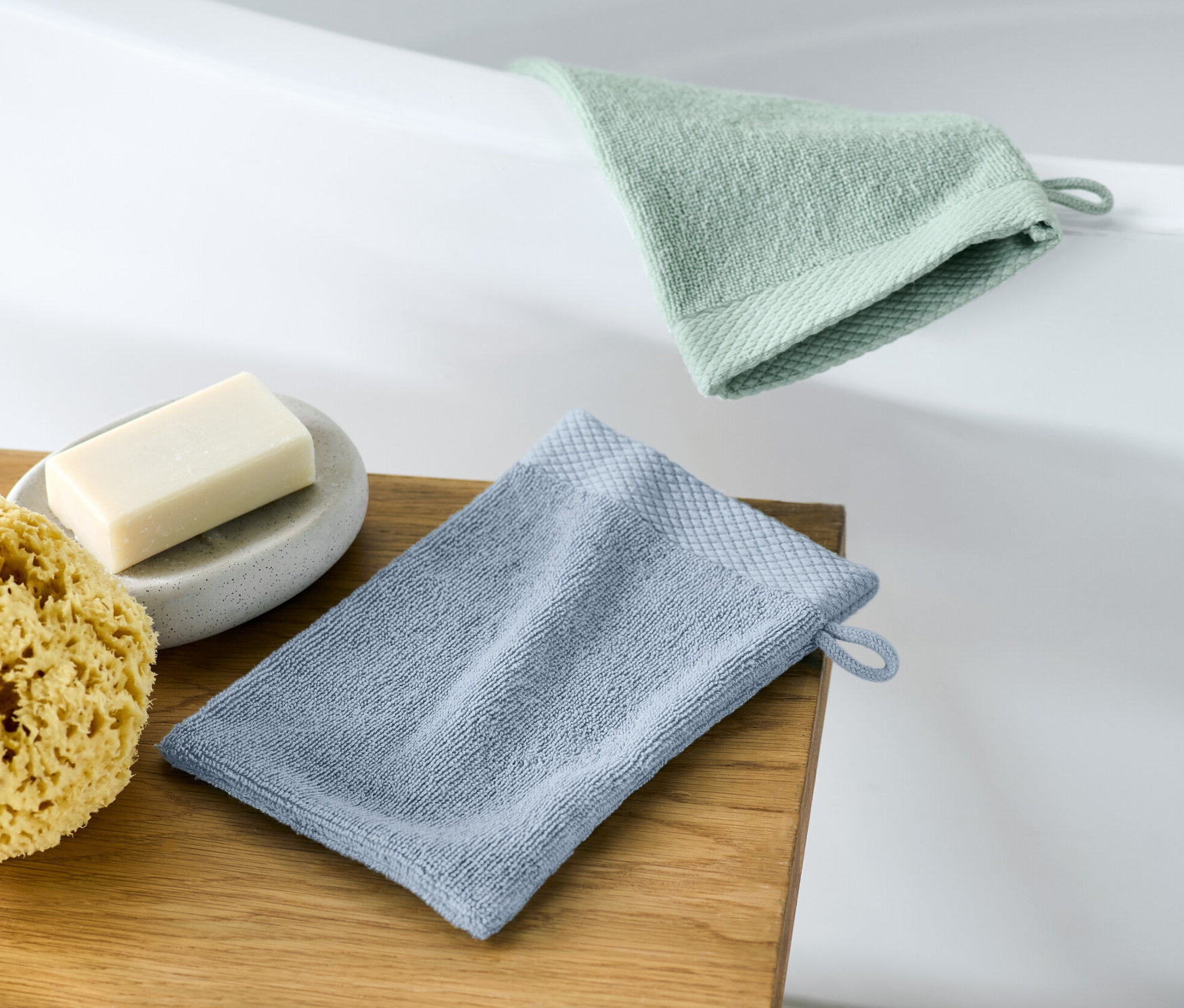 İki adet kese, sabun ve süngerin yanında ahşap bir tabure üzerinde duruyor.